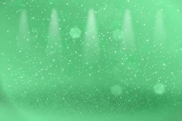 Verde muito brilhante brilho luzes desfocado palco holofotes bokeh fundo abstrato com faíscas voar, textura mockup festivo com espaço em branco para o seu conteúdo — Fotografia de Stock