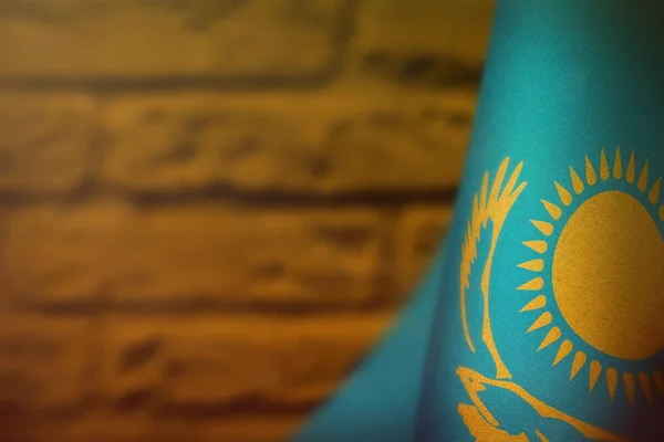 Kazakhstan flag for honour of veterans day or memorial day. Glory to the Kazakhstan heroes of war concept on orange blurred painted brick wall background. — Stock Photo, Image