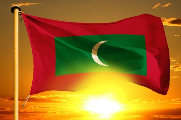 Мальдивские флаги плетутся на красивом оранжевом закате на фоне облаков — стоковое фото