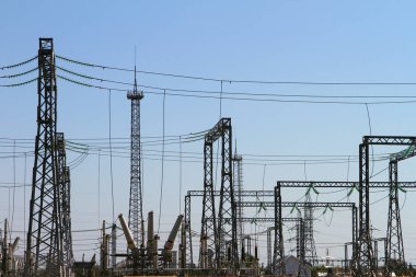 Yüksek voltajlı elektrik hatlarının direkleri ve mavi gökyüzü. Elektrik güç trafomerkezi