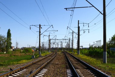 Mavi gökyüzü arka plan üzerinde yanları üzerinde elektrik direkleri bir sürü yaz aylarında kırsal tarafında Demiryolu yolu