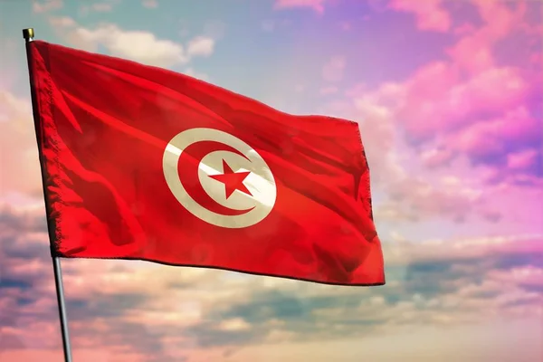 Fluttering Tunísia bandeira no fundo colorido céu nublado. Conceito de prosperidade . — Fotografia de Stock