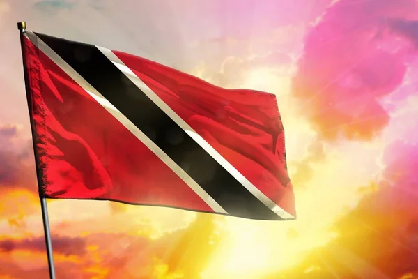 在美丽的五颜六色的日落或日出背景上飘扬的特立尼达和多巴哥国旗。成功理念. — 图库照片
