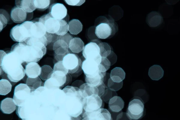 Licht blauw bokeh effect van glanzende vlekken op zwarte textuur-fantastische abstracte foto achtergrond — Stockfoto