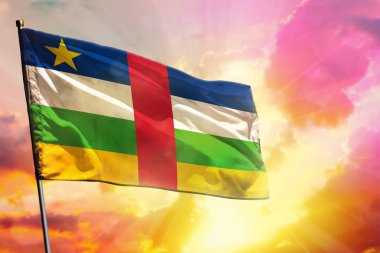 Güzel renkli günbatımı veya gündoğumu arka plan üzerinde fluttering Orta Afrika Cumhuriyeti bayrağı. Başarı konsepti.