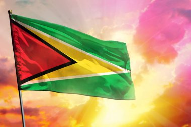 Güzel renkli günbatımı veya gündoğumu arka plan üzerinde Fluttering Guyana bayrağı. Başarı kavramı.