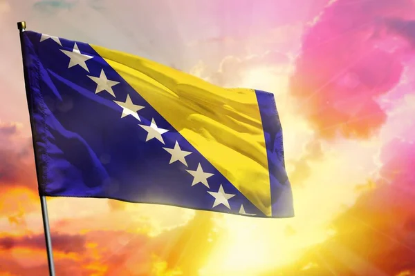 Güzel renkli günbatımı veya gündoğumu arka plan üzerinde Çırpınan Bosna-Hersek bayrağı. Başarı kavramı. — Stok fotoğraf