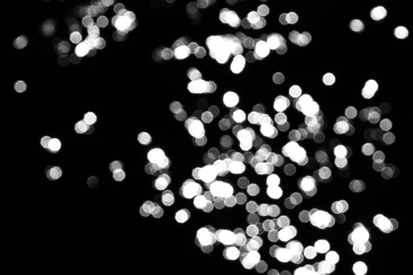 Bokeh effect of sparkling spots on black texture - cute abstract photo background — Stock Photo, Image