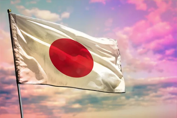 Fluttering Japan flag on colorful cloudy sky background. Prosperity concept.