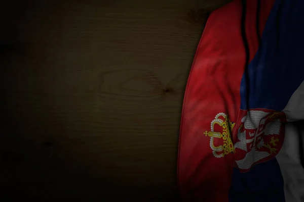 Ładny ciemny obraz flagi Serbii z dużymi fałdami na ciemnym drewnie z wolnym miejscem na tekst-dowolne święto flaga 3D ilustracji — Zdjęcie stockowe