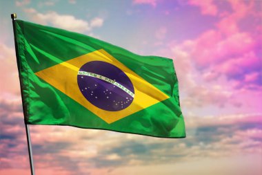Renkli bulutlu arka planda dalgalanan Brezilya bayrağı. Refah kavramı.