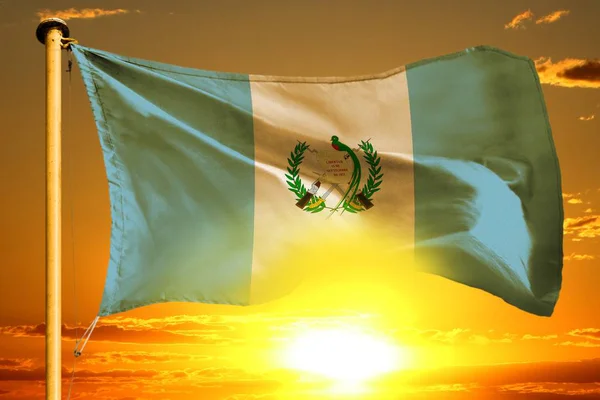 Guatemala bayrağı bulutların ardında güzel turuncu günbatımında sallanıyor. — Stok fotoğraf
