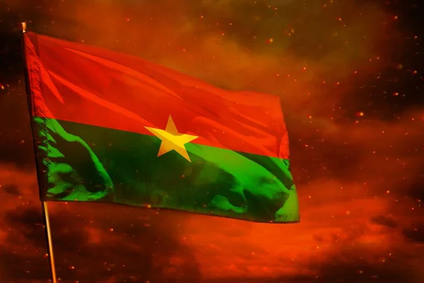 Burkina Faso zászlót lobogtatva a vörös égen, füstoszlopokkal a háttérben. Problémás fogalom. — Stock Fotó