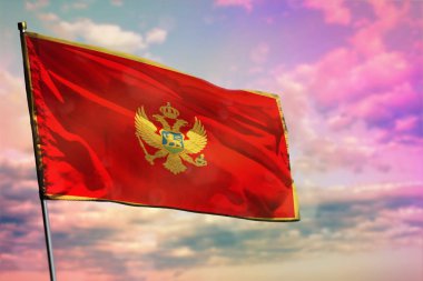 Renkli bulutlu arka planda dalgalanan Karadağ bayrağı. Refah kavramı.