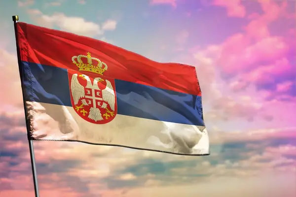 Vlající srbská vlajka na barevném kalném pozadí oblohy. Koncept prosperity. — Stock fotografie
