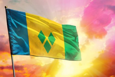 Güzel renkli günbatımında ya da gündoğumu arka planında dalgalanan Saint Vincent ve Grenadines bayrağı. Saint Vincent ve Grenadines başarı ve mutluluk konsepti.