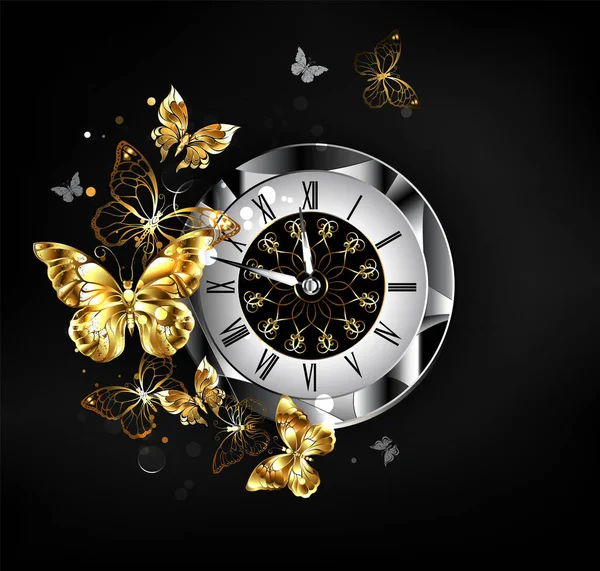 Antique clock, decorated with patterned dial, black latin numerals, with flying gold, jewelry butterflies on black background.