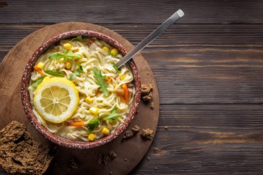 Yaprak roka Mısır ve tavuk eti bütün tahıl ekmeği kaşık Wabi Sabi stil düşük anahtar Asya yiyecek Çin kase sebze soğan havuç Yeşiller erişte çorbası.