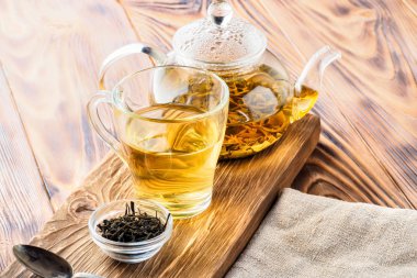 Geleneksel Çin yeşil çay içecek farklı fermantasyon cam Çaydanlık ve bardak taze demlenmiş yaprakları yiyecek konsepti kahvaltı rustik tarzı Wabi Sabi yaşam tarzı ahşap masa üzerinde sabah erkenden