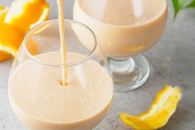 İki kokteyl cam ile smoothies milkshake sağlıklı içecek portakal narenciye peel muz süt yoğurt ve dondurma sağlıklı diyet gıda