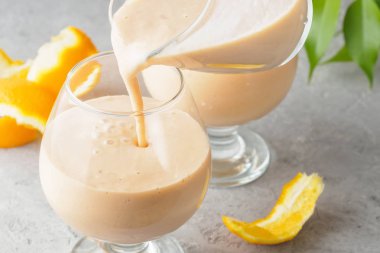 İki kokteyl cam ile smoothies milkshake sağlıklı içecek portakal narenciye peel muz süt yoğurt ve dondurma sağlıklı diyet gıda