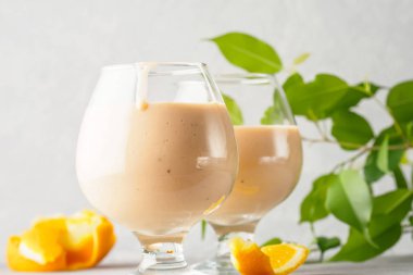 İki kokteyl cam ile smoothies milkshake sağlıklı içecek portakal narenciye peel muz süt yoğurt ve dondurma sağlıklı diyet gıda