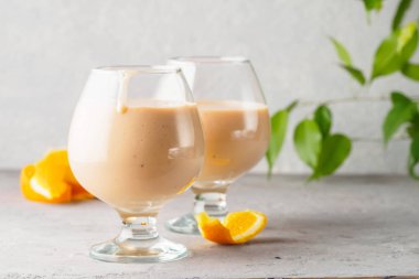 İki kokteyl cam ile smoothies milkshake sağlıklı içecek portakal narenciye peel muz süt yoğurt ve dondurma sağlıklı diyet gıda