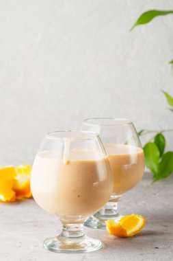 İki kokteyl cam ile smoothies milkshake sağlıklı içecek portakal narenciye peel muz süt yoğurt ve dondurma sağlıklı diyet gıda