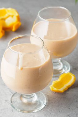 İki kokteyl cam ile smoothies milkshake sağlıklı içecek portakal narenciye peel muz süt yoğurt ve dondurma sağlıklı diyet gıda