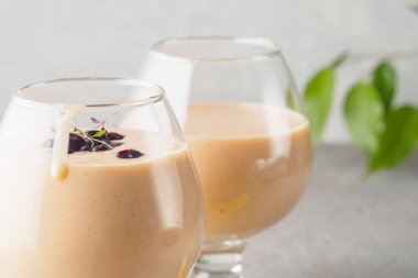 İki kokteyl cam ile smoothies milkshake sağlıklı içecek portakal narenciye peel muz süt yoğurt ve dondurma siyah frenk üzümü sağlıklı diyet yiyecek çilek ile