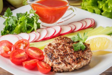 Kıyılmış biftek pirzola turp kiraz domates dilim salatalık maydanoz limon ve sosu ketçap kavramı gıda yaz ev yapımı piknik Barbekü assorty karışımı sebze ile beyaz tabakta ızgarada pişmiş