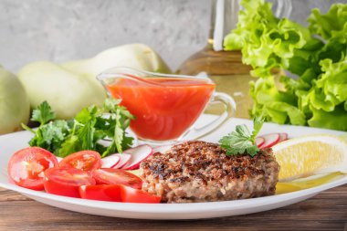 Kıyılmış biftek pirzola turp kiraz domates dilim salatalık maydanoz limon ve sosu ketçap kavramı gıda yaz ev yapımı piknik Barbekü assorty karışımı sebze ile beyaz tabakta ızgarada pişmiş