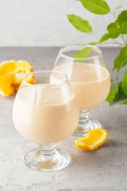 İki kokteyl cam ile smoothies milkshake sağlıklı içecek portakal narenciye peel muz süt yoğurt ve dondurma hareket sürahi damla sağlıklı beslenme elma püresi