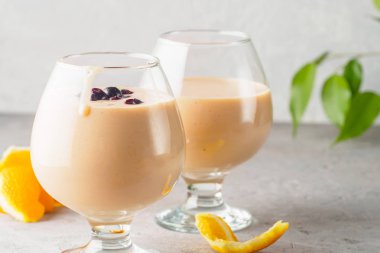 İki kokteyl cam ile smoothies milkshake sağlıklı içecek portakal narenciye peel muz süt yoğurt ve dondurma siyah frenk üzümü sağlıklı diyet yiyecek çilek ile
