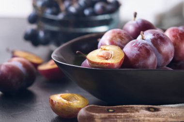 Kendi elleri hasat kopya alanı ile tarım üstten görünüm tarafından bütün taze Olgun kırmızı menekşe mavi Erik ve dilimleri bıçak kase ile mutfak masasında ev yapımı reçel kompostosu pişirme kavramı kesmek yapmak.
