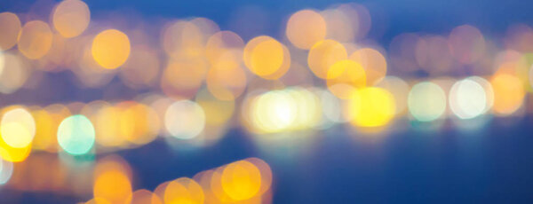 Abstract background selective focus bokeh lights of big city sea coast night bright toned