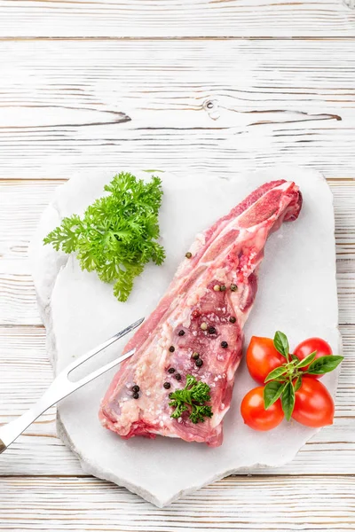 Stück Schweinebraten Rippenspachtel mit Salz und Pfeffer und Basilikumzweig gewürzt — Stockfoto