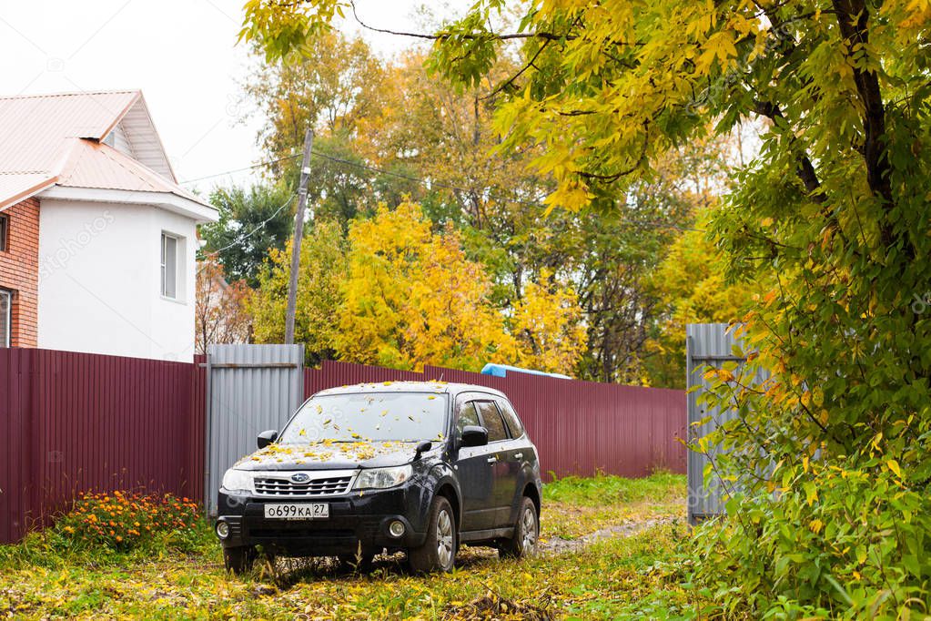 KHABAROVSK, RUSSIA - SEPTEMBER 23, 2018: SUBARU car with yellow autumn leaves on its hood in the countryside