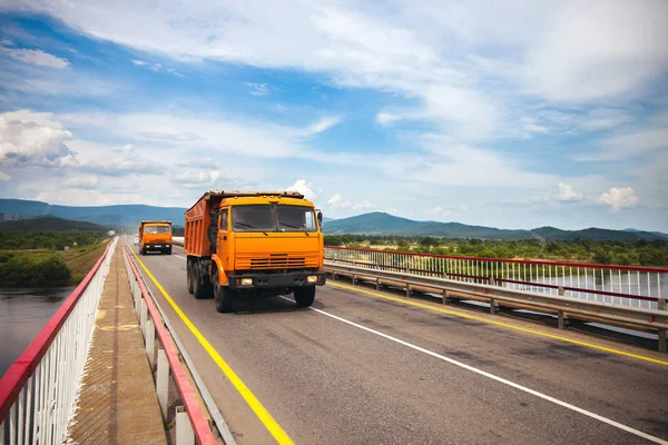 Zwei Orangefarbene Russische Muldenkipper Fahren Über Die Brücke — Stockfoto