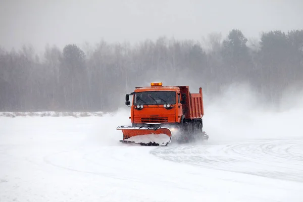 冬の雪嵐の中に道路を清掃除雪トラック — ストック写真