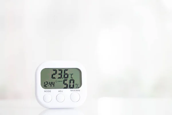 Biały higrometr elektroniczny na białym stole — Zdjęcie stockowe