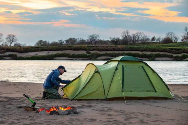 Turist nehir kıyısındaki kampında çadır kuruyor.. — Stok fotoğraf