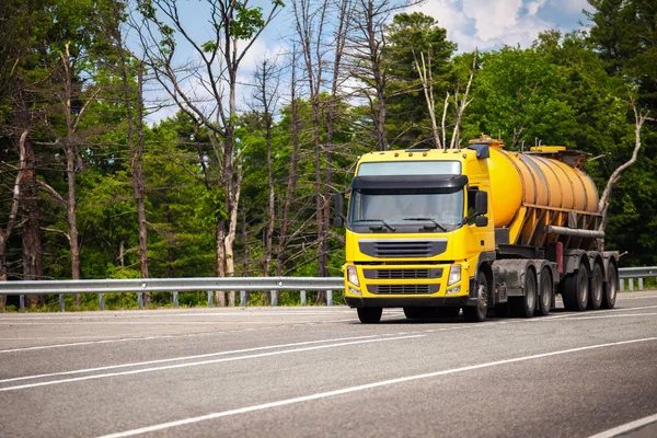 Żółty samochód ciężarowy z naczepą z pomarańczowym zbiornikiem — Zdjęcie stockowe