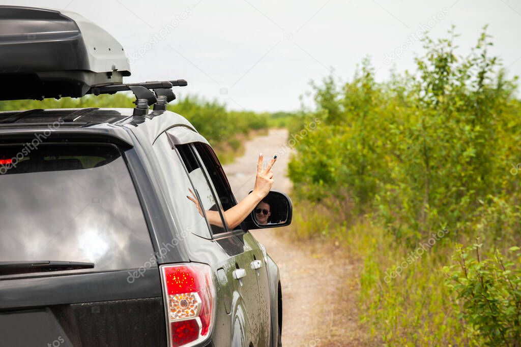 Female driver shows victory symbol from her car window