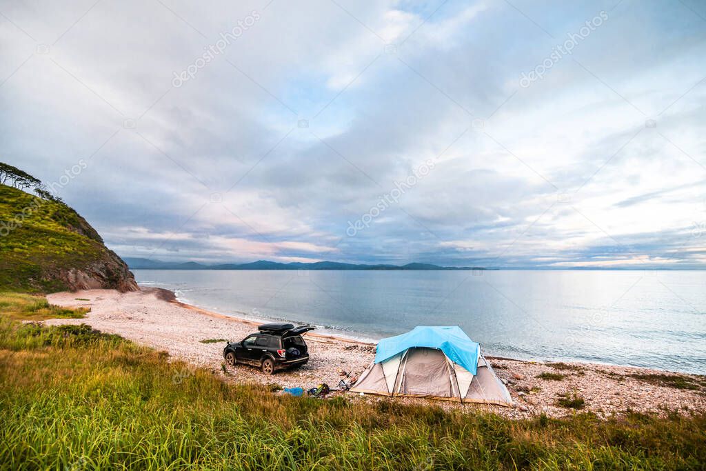 Tent camping at the sea coast. Black car near the tent