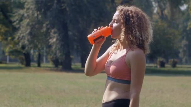 Mujer joven bebiendo agua después de correr — Vídeos de Stock