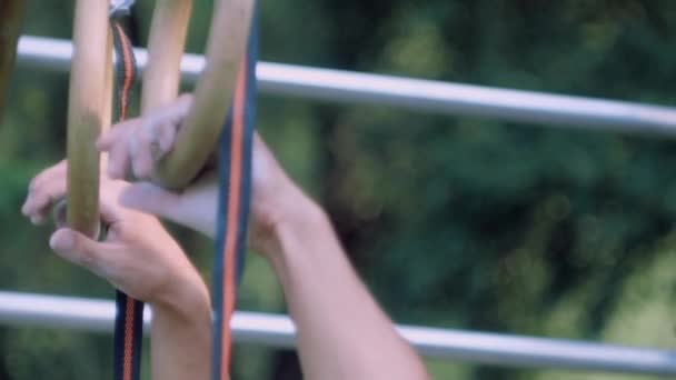 Близько - вгору на дитячому майданчику чоловічі руки захоплюють гімнастичне кільце — стокове відео