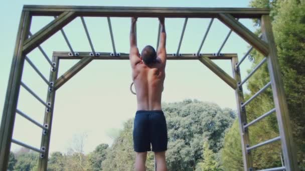 Fuerte atleta haciendo pull-up en la barra horizontal al aire libre — Vídeos de Stock