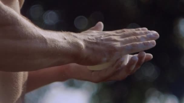 Sportowiec ręce klaskanie z białym Kreda krawiecka w proszku, który wybucha w zwolnionym tempie cząstki pyłu — Wideo stockowe