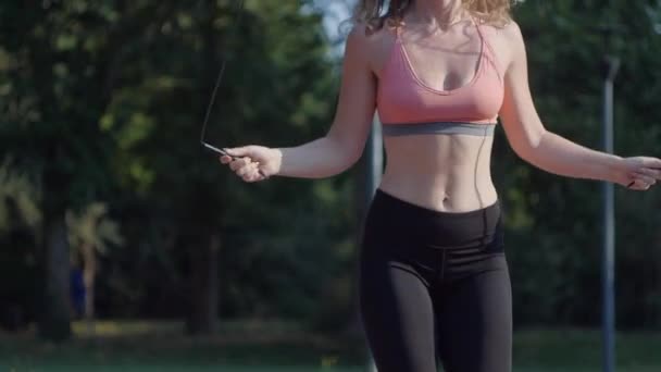 Uma mulher de roupa esportiva pula corda — Vídeo de Stock